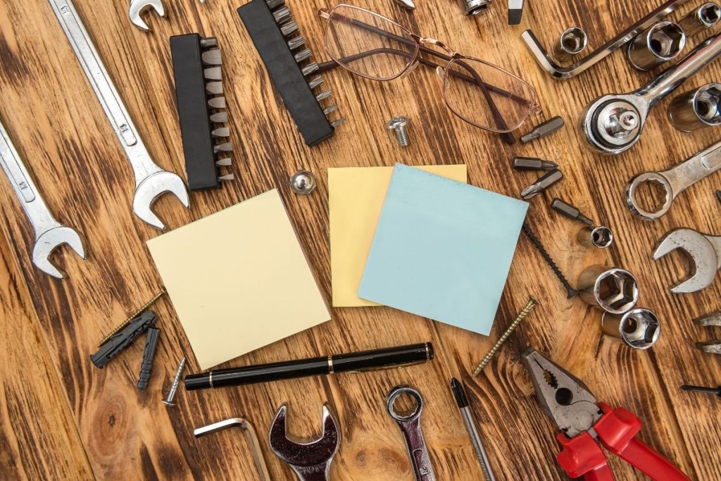 1. A wooden table displaying various tools, including wrenches, alongside a notepad for notes or measurements.
